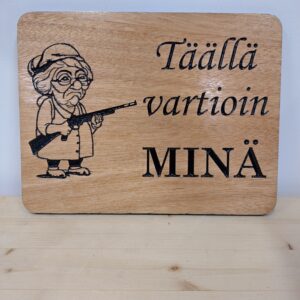 Täällä vartioin minä -kyltti mummon kuvalla